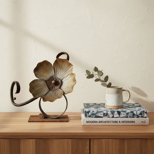 Metal Morph Sculpture Flourish handcrafted steel botanical flower art on a wooden console table with books and a mug.