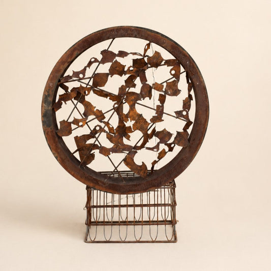 Metal Morph Sculpture Rust & Radius circular steel art piece with a rusted patina finish on a vintage metal base.