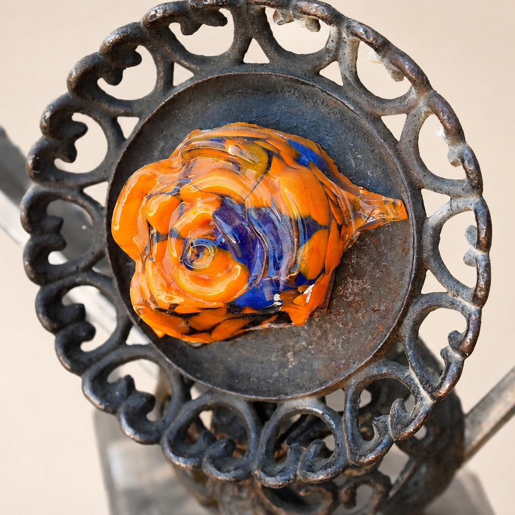 Metal Morph Sculpture Molten Geometry detail showing a vibrant orange and blue glass flower set in vintage cast iron.