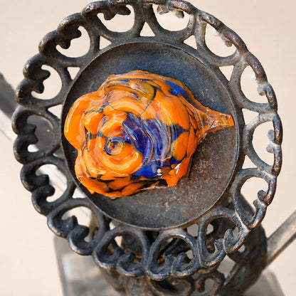 Metal Morph Sculpture Molten Geometry detail showing a vibrant orange and blue glass flower set in vintage cast iron.