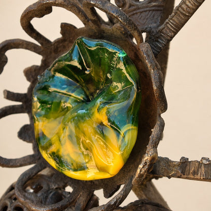 Metal Morph Sculpture Molten Geometry detail featuring a vibrant green and yellow glass flower set in vintage cast iron