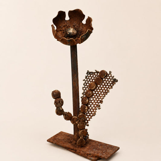 Metal Morph Sculpture handcrafted steel floral art made from recycled industrial scrap metal with a mesh backdrop.