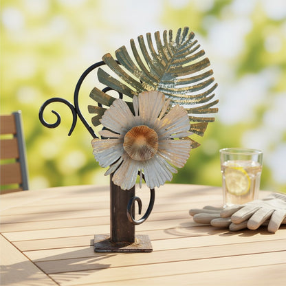 Metal Morph Sculpture handcrafted industrial steel flower and leaf art piece with a rustic finish on a patio table.