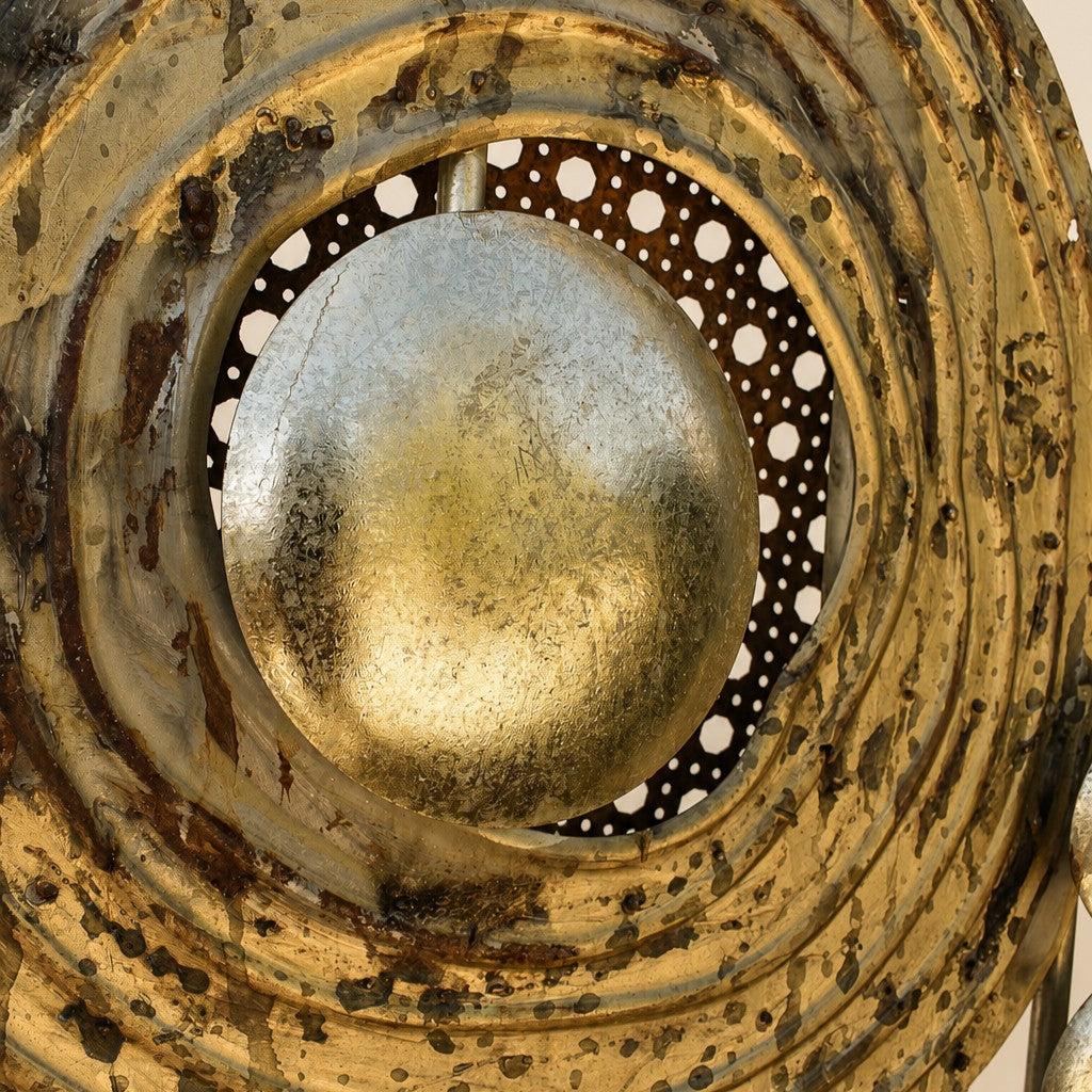 Close-up of Metal Morph Sculpture Madame Orbit featuring a weathered gold metallic sphere centered in layered rings