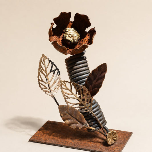 Metal Morph Sculpture Spring Bloom handcrafted steel flower with rust patina, gold weld-bead center, and coiled stem.